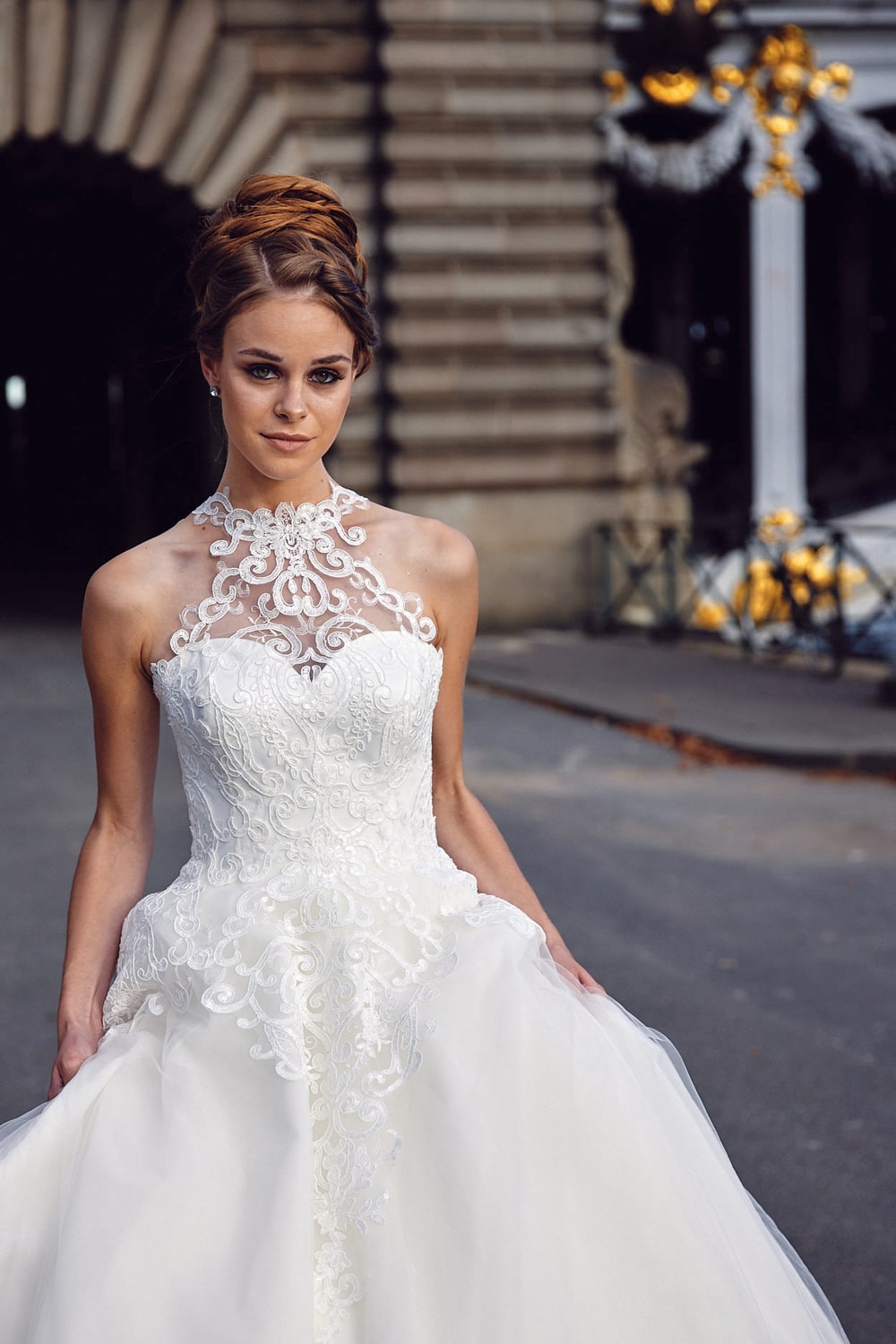A bride photographed under a gilded arcade, the columns falling away behind her
