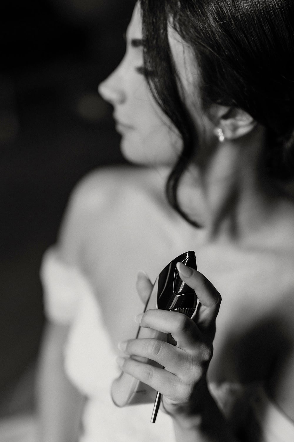 The turn of a bride’s shoulder and jaw in profile, close and very soft